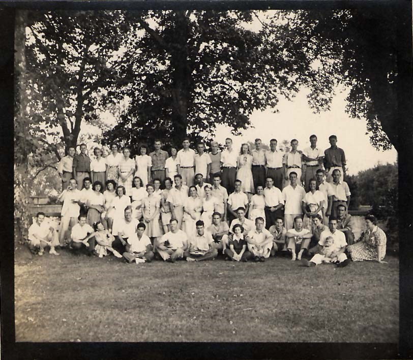 Black-and-white Photograph of CPS Camp 49 members. A total of fifty-six men and women are sitting and standing in three rows outside.