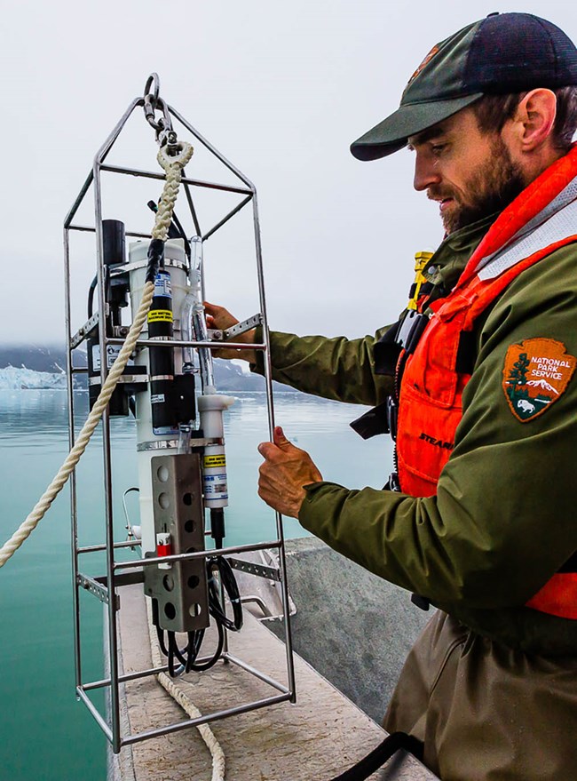 A scientists readies an instrument for oceanography measurement.
