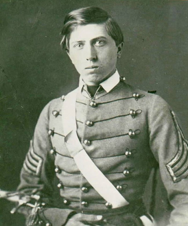 Black and white historical photo of a youthful army officer in dress uniform.