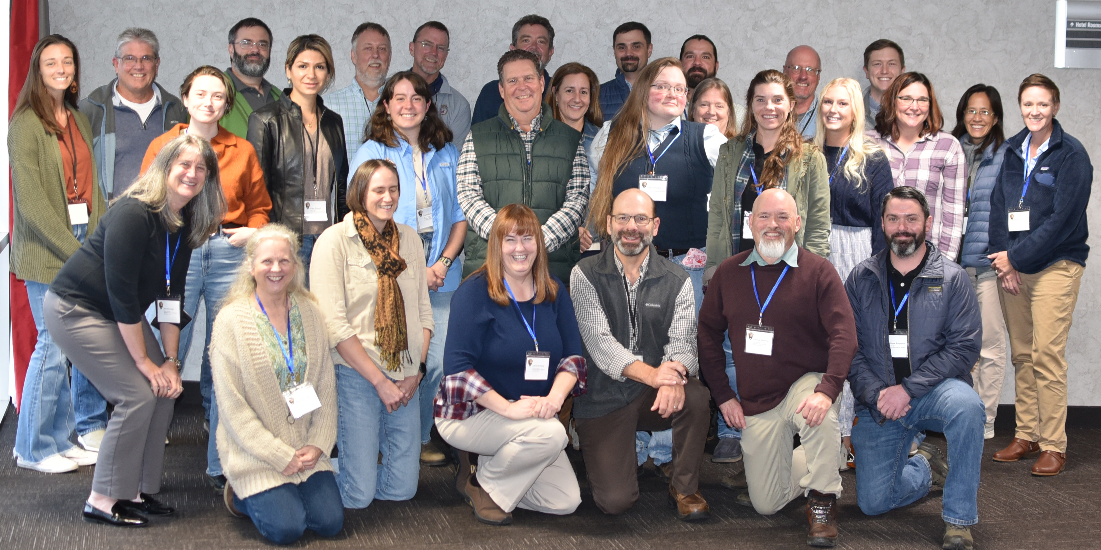 Group of people wearing name tags around their necks posing for a photo.