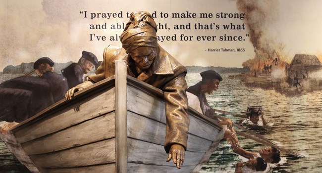 Statue of Harriet Tubman in a boat reaching for people in the water