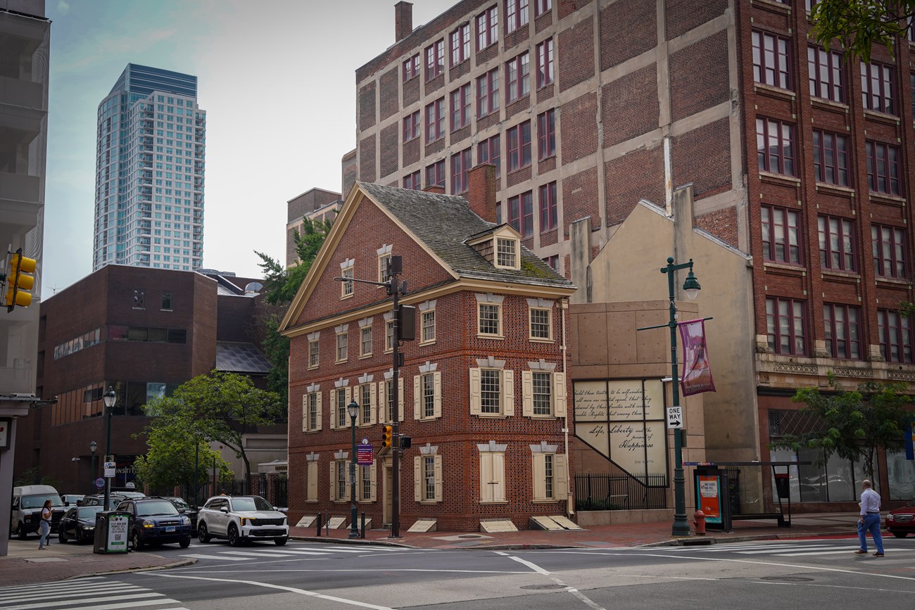Three story brick house with cream colored window shutters