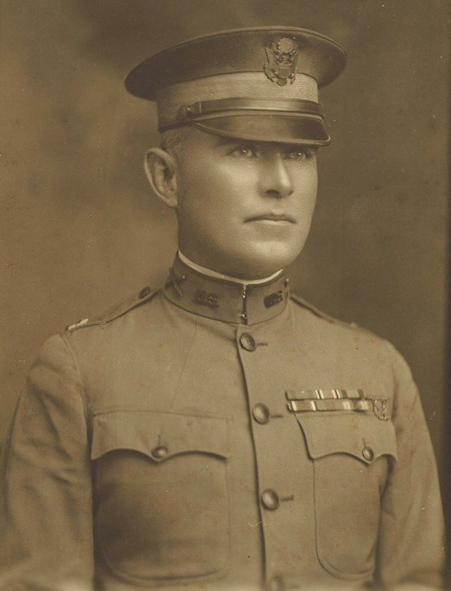 A black and white photograph of a soldier in a World War I-era uniform.