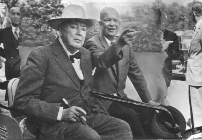 A black and white image of Dwight Eisenhower and Winston Churchill in a golf cart