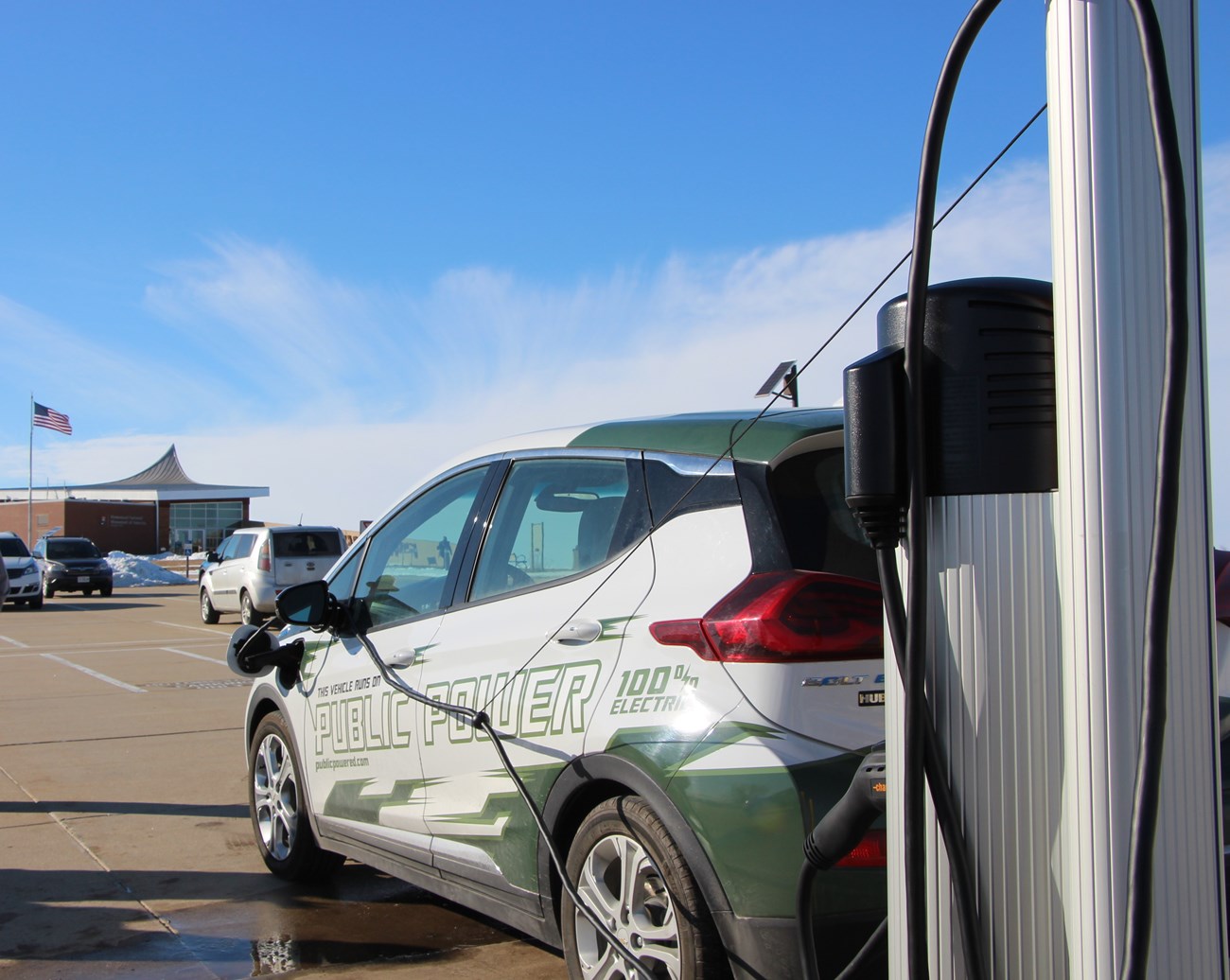 An electric vehicle parked and plugged into a electric charging station.