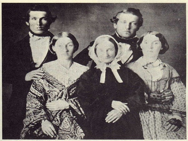 faded photo. from left to right- man, woman, woman, man, woman