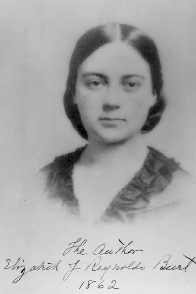 A vintage black and white photograph of a woman, capturing her expression and style from an earlier time.