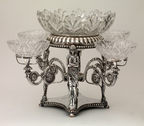 A silver Epergne with a white background.