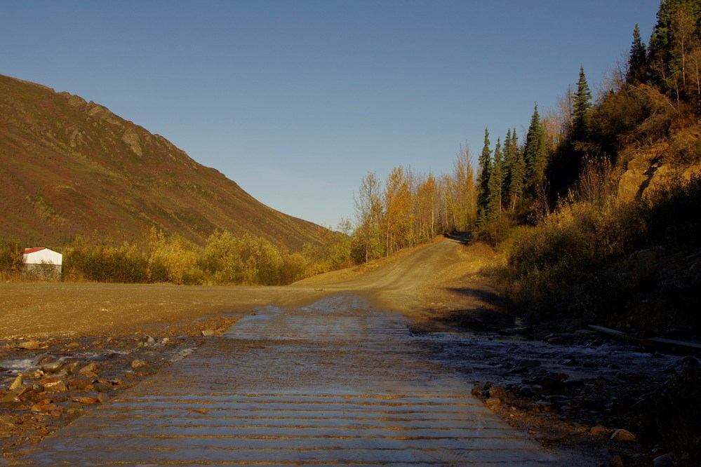 Park road crossing a creek that is flowing over it