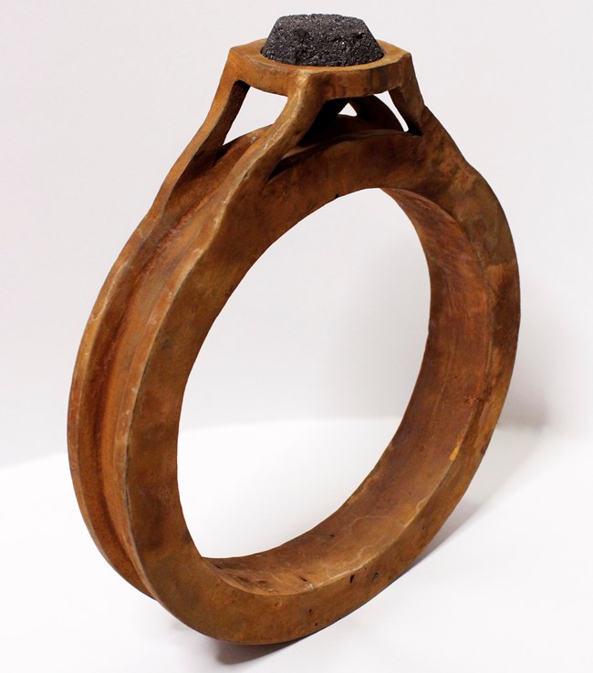 An oversized cast iron ring with an orange patina