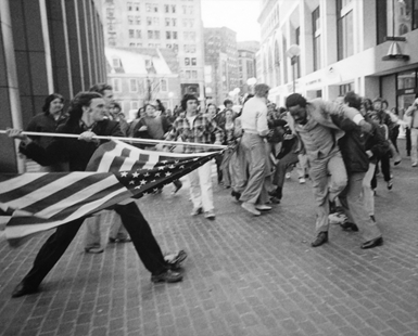 A man wielding an American flag on the right