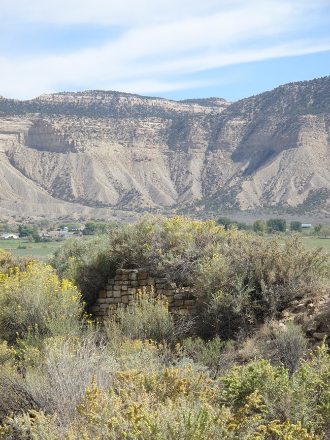 stone house ruins with mesa in the distance