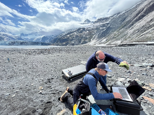 Researchers ready a UAS for operation on a beach with mountains in the background.
