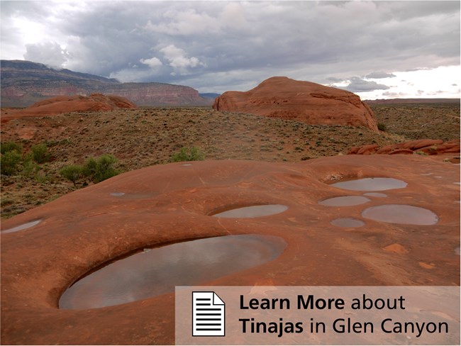 Eroded circles in red sandstone filled with water.