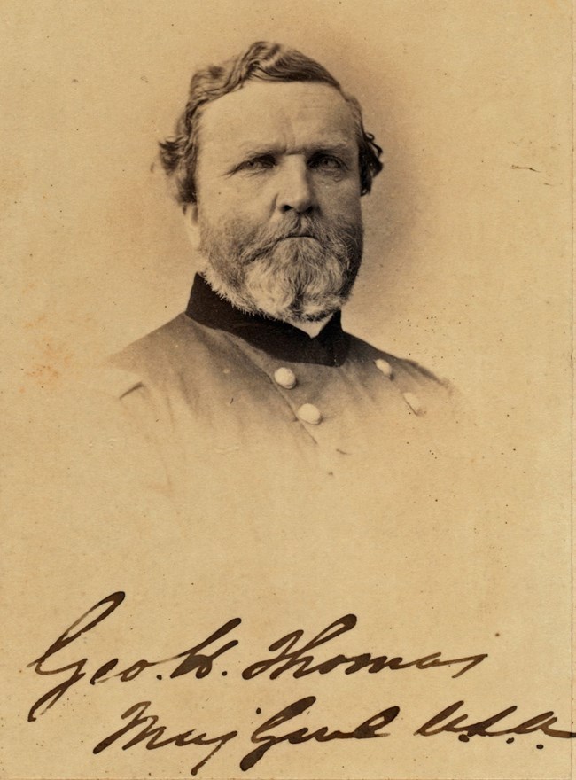A sepia toned image of Thomas in uniform sitting.
