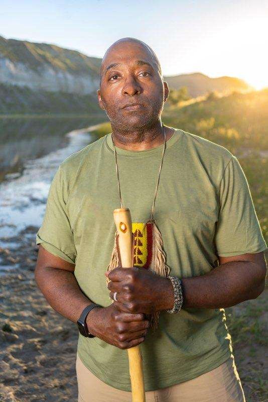 black man standing by a river