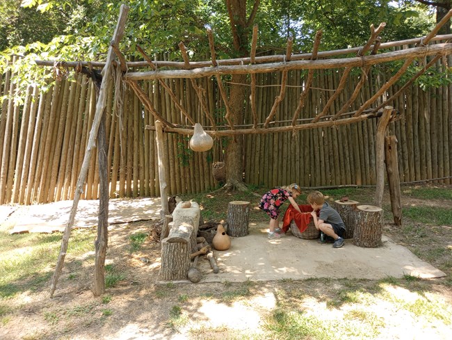 Children playing in s reproduction Indian village.