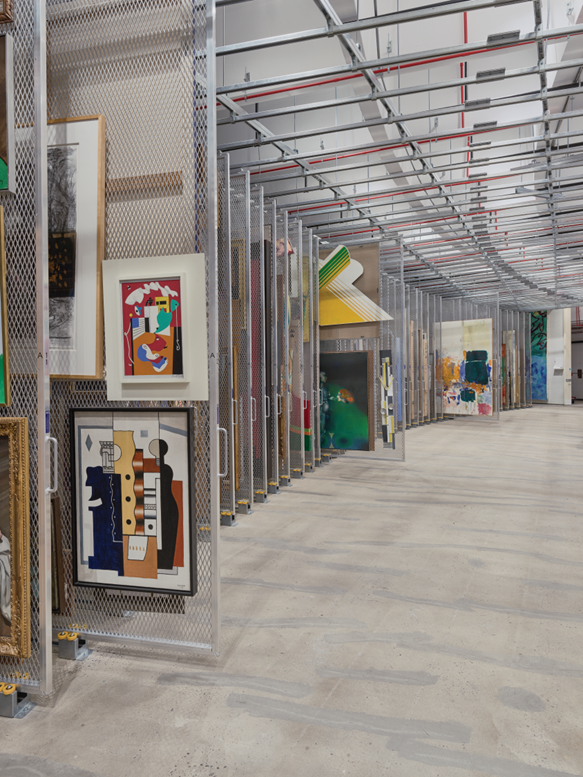 A curved utilitarian space with multiple tall pull-out panels holding paintings.