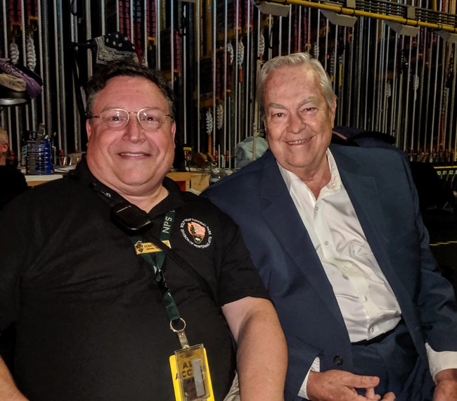 Two white males pose for a photo backstage.