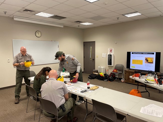 Four staff members stand around a table in a classroom setting.