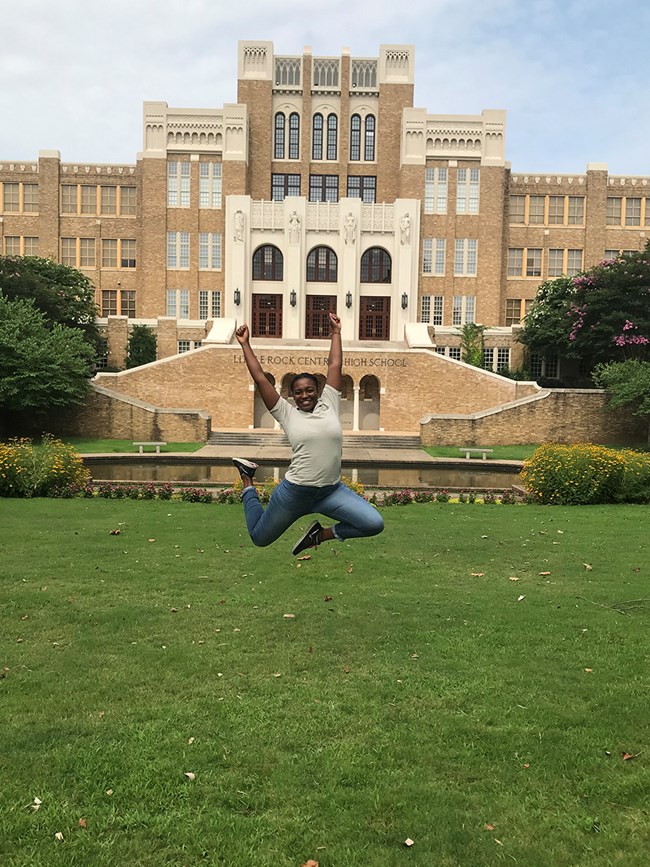 Alyssa jumping in front of Little Rock Central High School