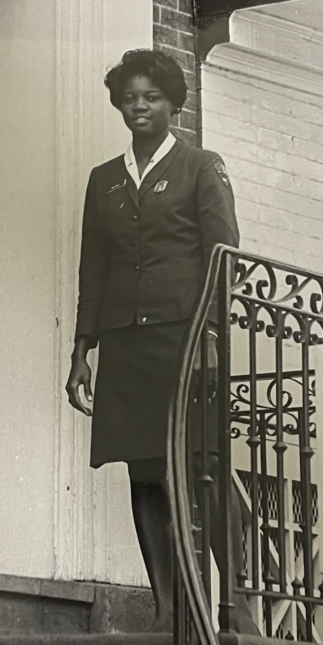 African American woman standing outside on a stair landing in uniform