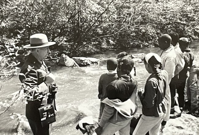 Children and a ranger beside a river
