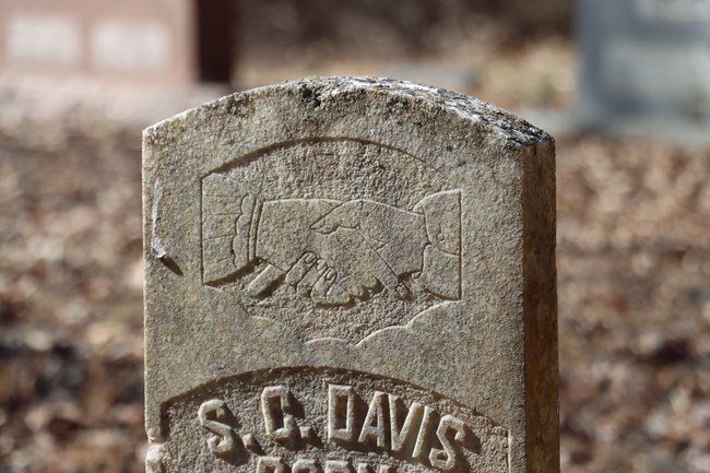 A closeup of a carving of two hands clasped