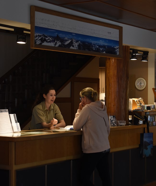 Visitor talking to a volunteer behind a desk