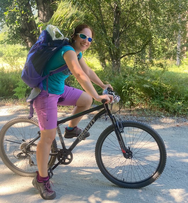 Elisa carrying true grass on a bike