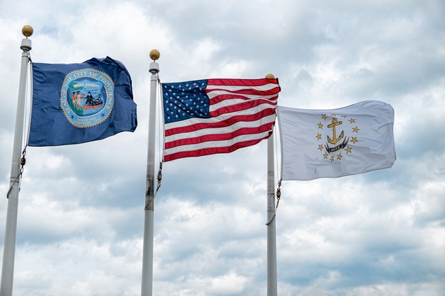 A flag from the city of Providence, an American flag, and a flag of Rhode Island