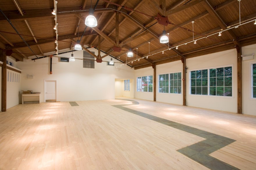 Large open room with tan floor inlaid stone line goes from on end to another.