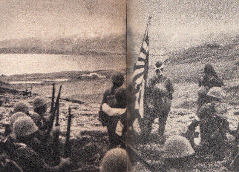 Japanese soldiers stand on US soil, looking out at sea. They hold a Japanese flag.
