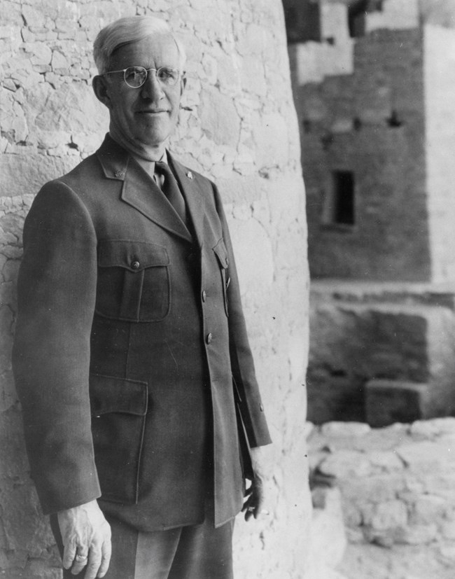 Man in uniform standing next to ruins