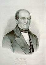 Grayscale bust portrait of John Bell. He is dressed in a suit jacket and tie looking toward the audience.