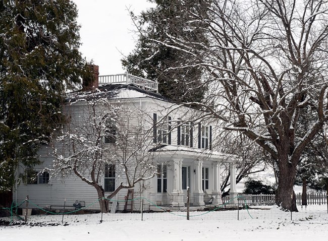 Old, grand house covered in snow.