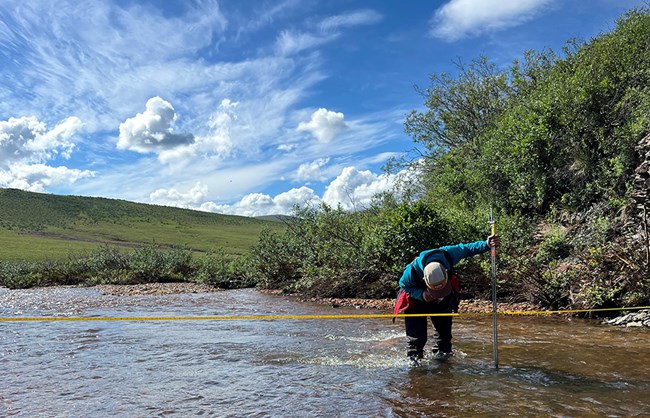 A scientist measuring flow of a river.