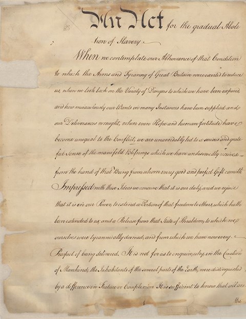 A faded yellow document with black hand written text of the Pennsylvania Gradual Emancipation Act.