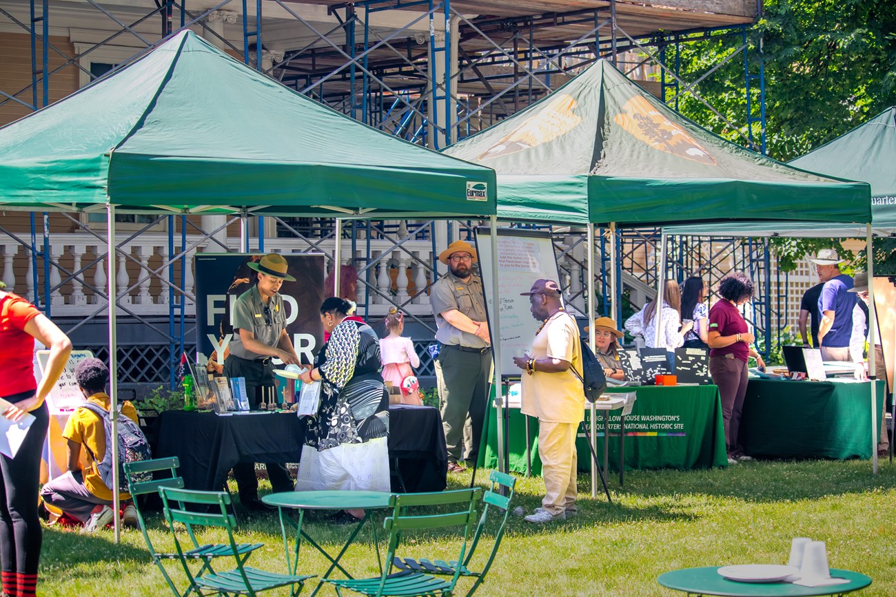 Staff and visitors mingling under outdoor tents