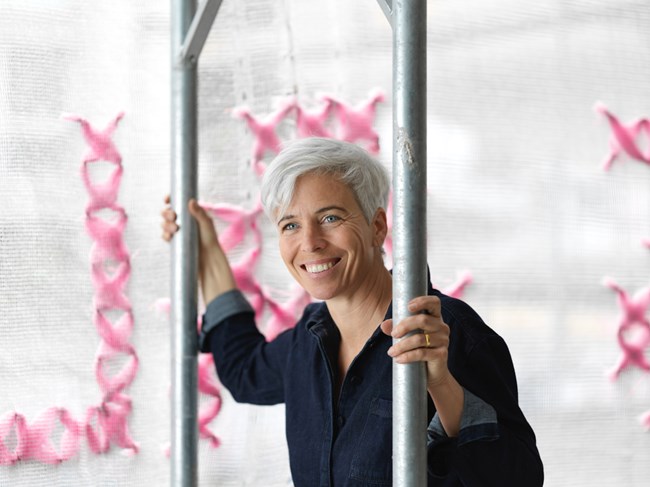 Woman smiling at camera during installation of large public art piece