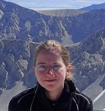 Headshot of woman wearing glasses with mountains in the background