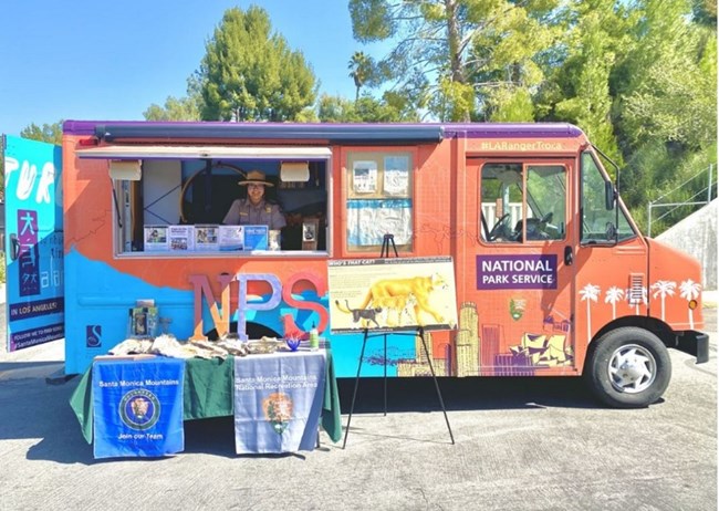 lei inside a colorful truck with the letters NPS and signs about different animals