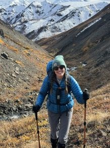 Female hiker with hiking poles smiling at the camera