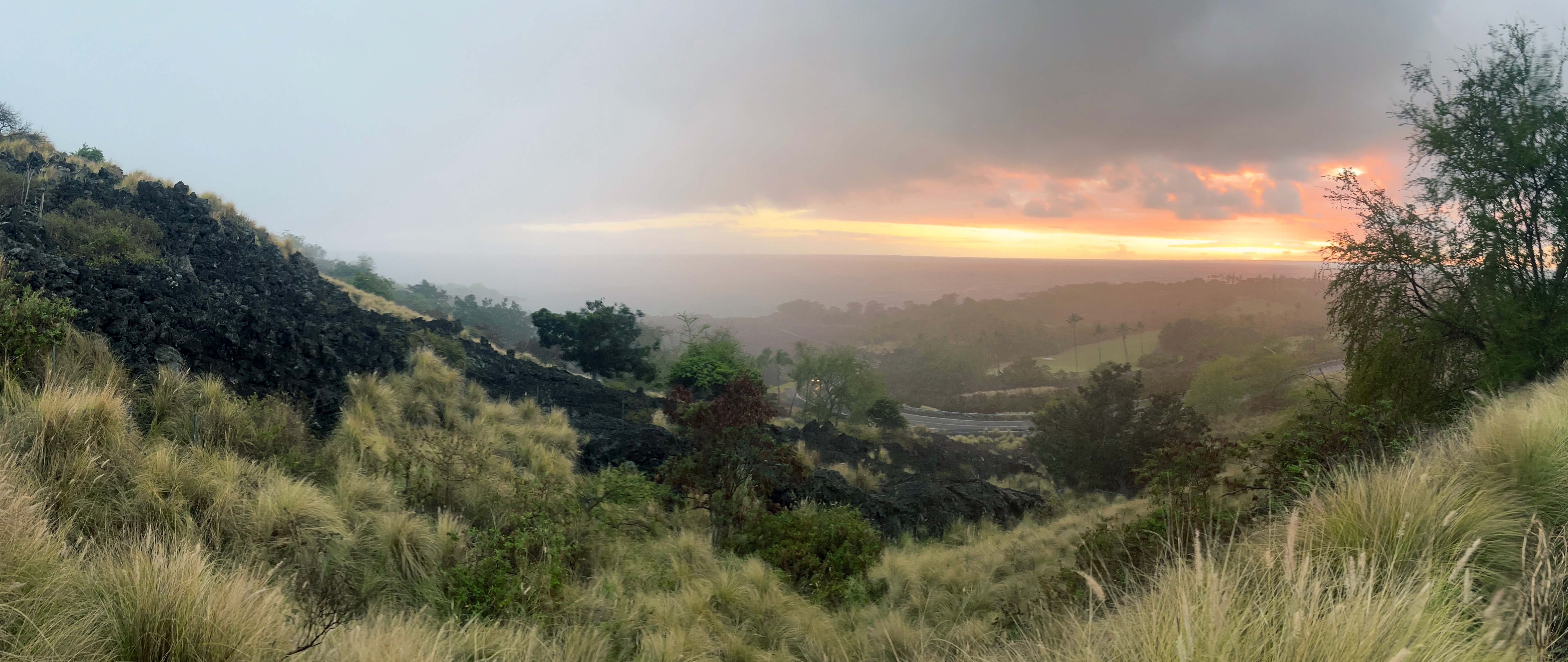 Sunset view of lava fields of rough stone, now overgrown with brush.