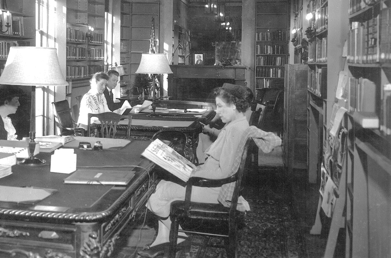 Several people seated at tables reading in NWP library