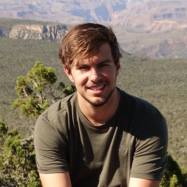 Closeup of man sitting outdoors smiling at camera