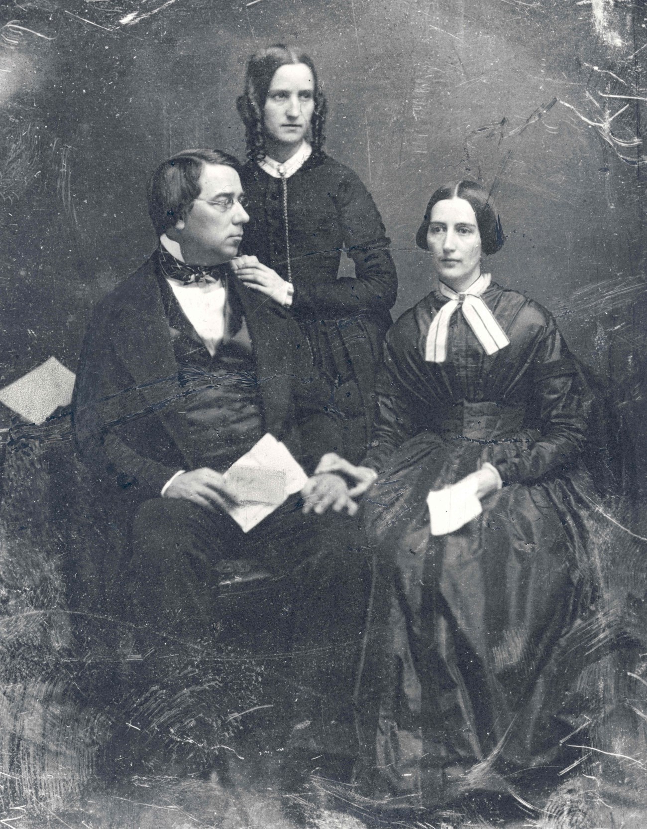 black and white historic portrait photo, George Perkins Marsh sits next to first wife Caroline Crane Marsh, Lucy Crane stands behind with hand on GPM's shoulder