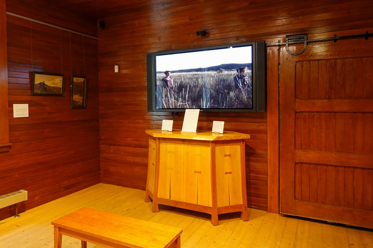 Framed black and white photographs of the Grand Tetons with a screen showing the artist Ellen Smith Ahern