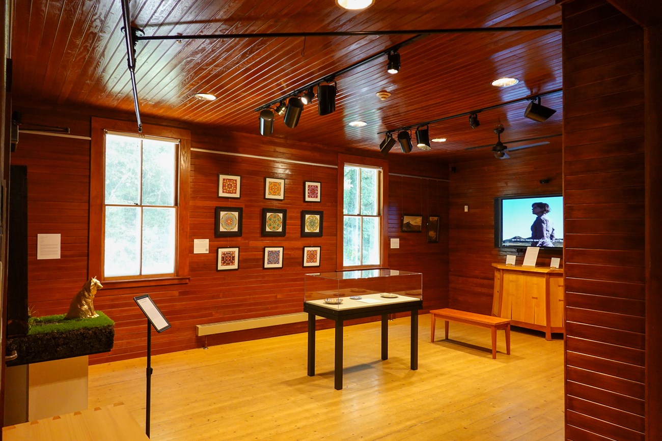 Multiple pieces of art with signs and cases in the Marsh-Billings-Rockefeller Visitor Center