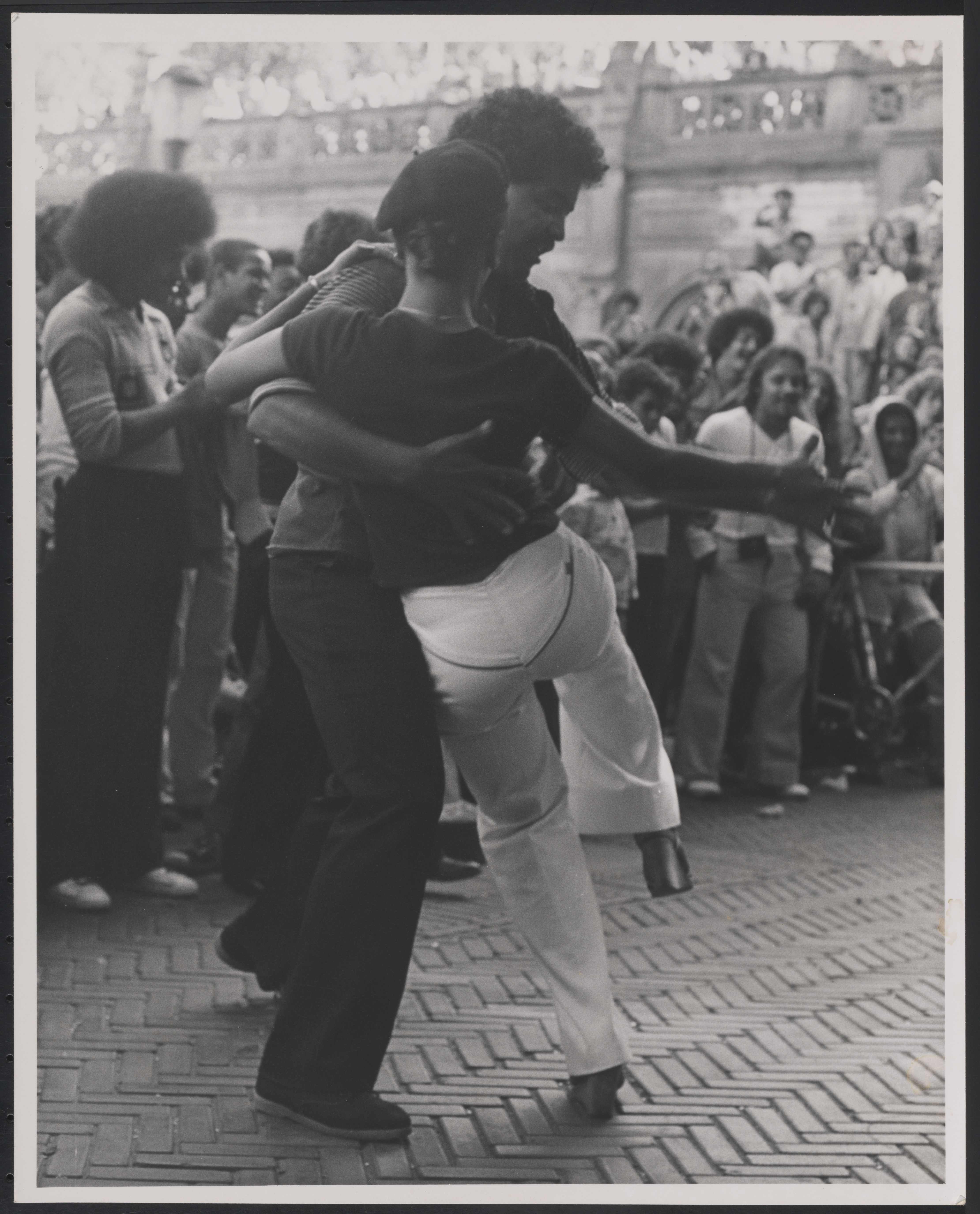 Two people dancing in front of a crowd. Black and white photo.
